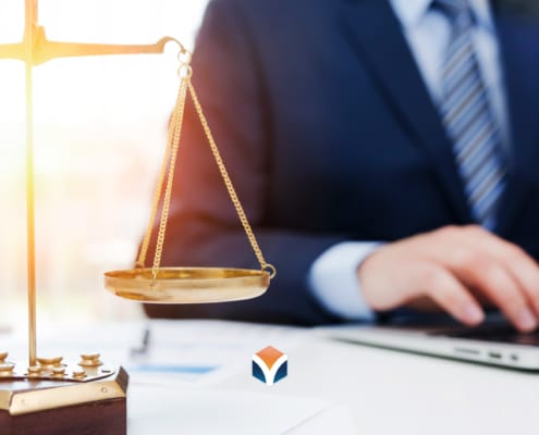 lawyer on computer with scales of justice on the desk